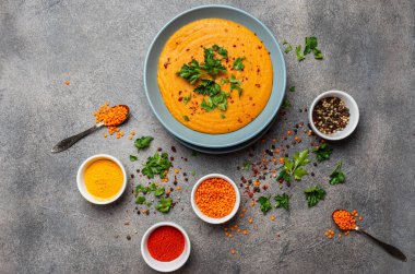 Geleneksel Hint çorbası mercimekleri. Hint Dhal baharatlı köri, baharatlar, otlar, kırsal gri ahşap arka plan. Otantik Hint yemeği. Üst görünüm.