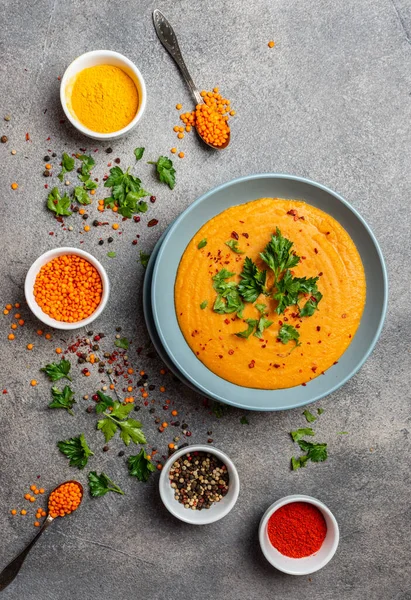 Indian dal. Traditional Indian soup lentils. Indian Dhal spicy curry in bowl, spices, herbs, rustic grey wooden background. Authentic Indian dish. Top view.