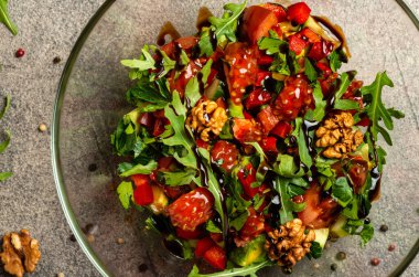 Sebze salatası, roka, domates, avokado, cam kasede balzamik sos. Üst görünüm.