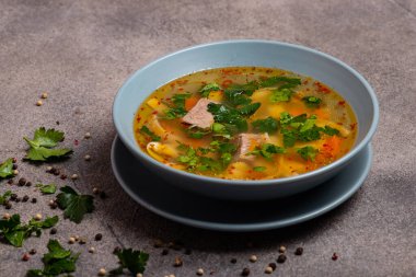 Gri arka planda biftek ve şehriye ile lezzetli baharatlı çorba..