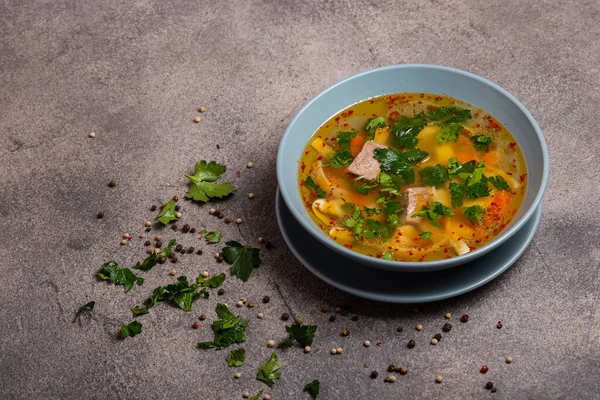 Köstliche würzige Suppe mit Rindfleisch und Nudeln auf grauem Hintergrund. Kopierraum für Text. — Stockfoto