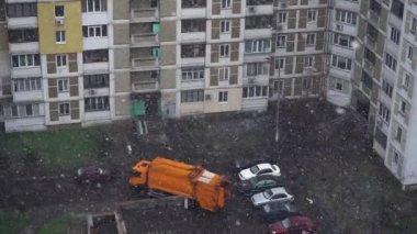 Çöp kamyonu çöpleri toplamak için avluya çıkıyor. Baharda şehirde kar fırtınası. Yavaş çekim