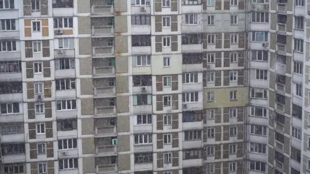 Nieve fuerte en la ciudad cerca del edificio de gran altura. Primer plano. Movimiento lento — Vídeo de stock