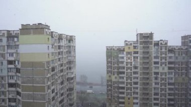 Şehrin yüksek binasının yakınında yoğun kar var. Yavaş çekim.