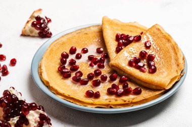 Nar ve yoğunlaştırılmış sütle kaplı krepler bir tabakta yatar. Yakın plan..