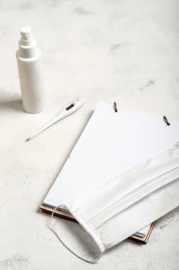 Günlük hayatta nessesary öğeler. Coronavirus önleme tıbbi cerrahi maske, el temizleyici jel, dijital termometre ve beyaz arka planda not defteri..