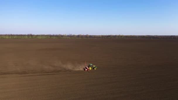 Vista aérea del tractor tirando de la siembra de taladro de semillas en el campo — Vídeos de Stock