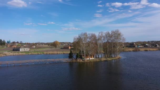 Letecký pohled na ranní krajinu, Dřevěné lovecké vily, na malém ostrově. — Stock video