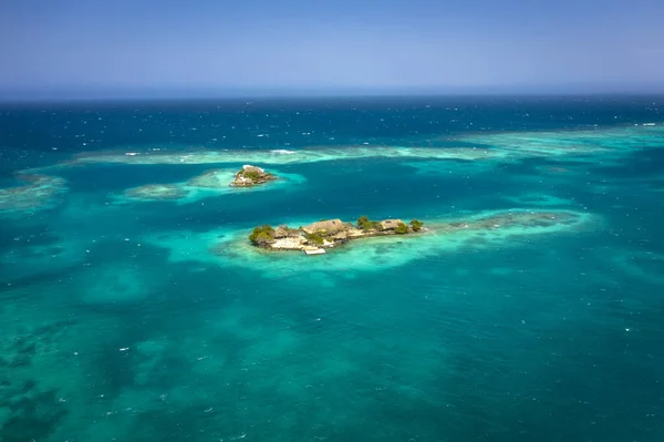 Vista aérea del dron volador de la soleada isla paradisíaca tropical con el océano de agua de mar de cielo azul aguamarina. Isla con hotel unifamiliar . — Foto de Stock