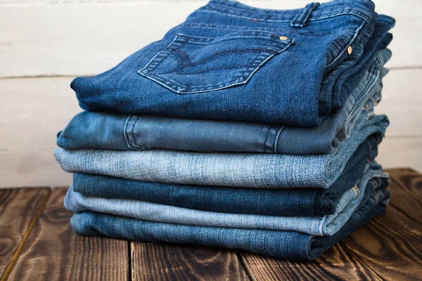 Pila de jeans en tablero de madera — Foto de Stock