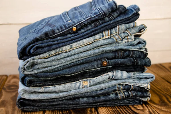 Pila de jeans en tablero de madera — Foto de Stock