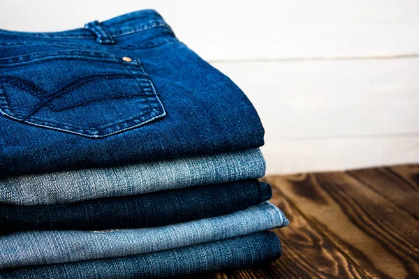 Pile de jeans sur planche en bois — Photo