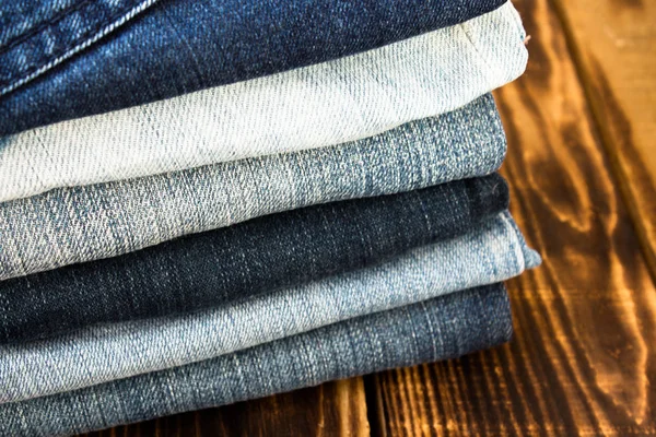 Pila de jeans en tablero de madera — Foto de Stock
