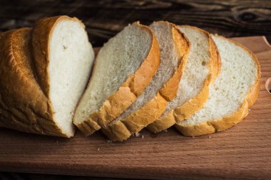 ahşap arka plan üzerinde ekmek dilimlenmiş