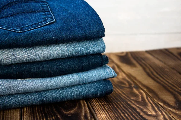 Pila de jeans en tablero de madera — Foto de Stock