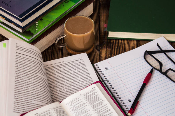 Библейская стопка книг, блокноты, очки
