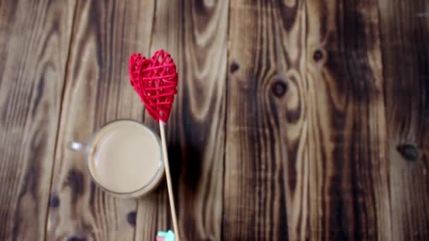 Cup of coffee and handmade heart in hand — Stock Video