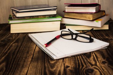 Kitaplar, pecil, defter, gözlük, çalışma yığını