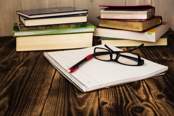 Kitaplar, pecil, defter, gözlük, çalışma yığını