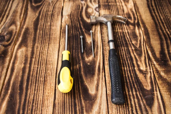 Clavo de martillo, tornillo y destornillador sobre fondo de madera —  Fotos de Stock