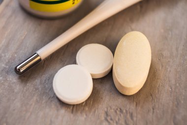 termometre ahşap arka plan üzerinde beyaz hap ile