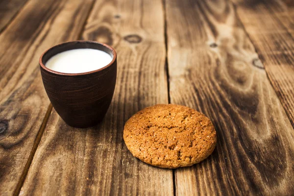 Овсяные печенья с молоком на деревянном фоне — стоковое фото