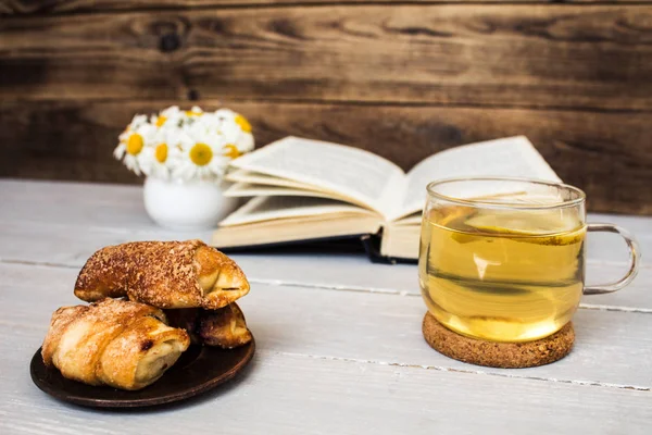 book and tea daisies croissants on wood