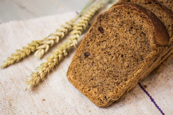Домашний хлеб и пшеница на светлом деревянном фоне — стоковое фото