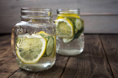 Salatalık ve limon dilimleri ile bir içkiyle iki kavanoz