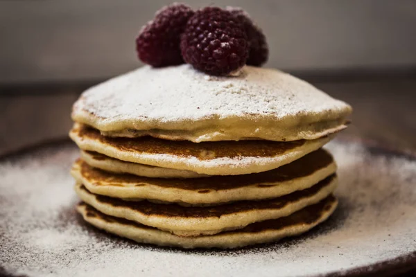 Stack of pancakes with sugar powder and raspberry — Stock Photo, Image
