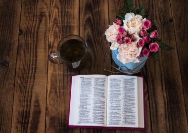 roses tea and bible on wooden clipart