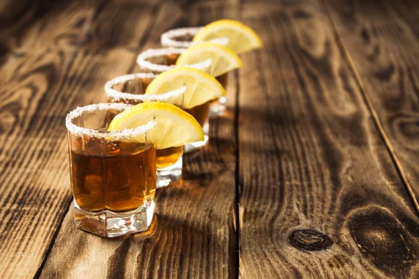 Quatro copos de bebida alcoólica com limão — Fotografia de Stock