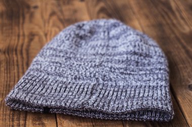 gray winter warm hat on a wooden bacground
