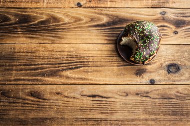 ahşap arka plan üzerinde çikolata ile ısırıldı çörek