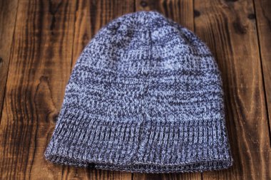gray winter warm hat on a wooden bacground