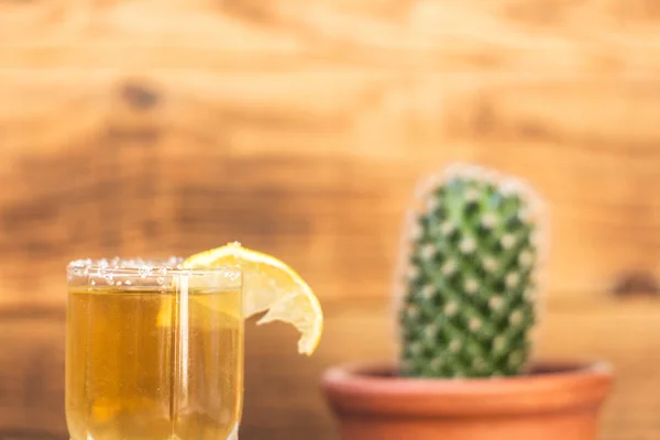 Tequila met citroen en cactus op een houten achtergrond — Stockfoto