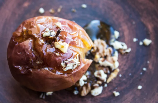 Dessert with baked apple of honey and nuts on a clay plate — Stock Photo, Image