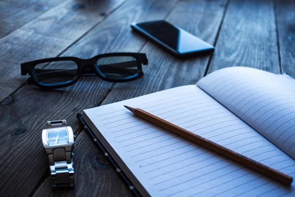 Σημειωματάριο και μολύβι ρολόι τηλέφωνο glasseson ξύλινο bacground — Φωτογραφία Αρχείου