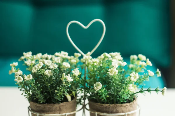 Florero con flores silvestres y el corazón en la mesa — Foto de Stock