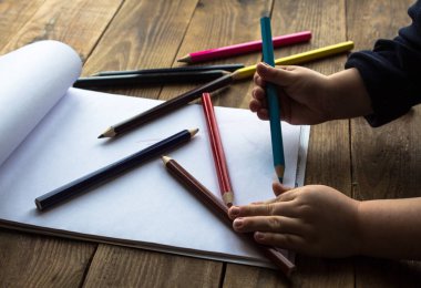 küçük çocuk beyaz kağıt üzerine çizer