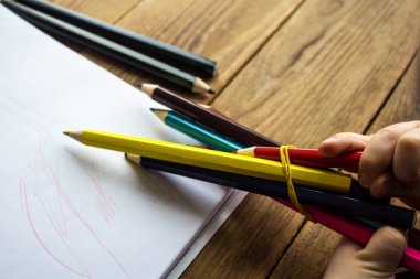 küçük çocuk renkli kalemler tutar