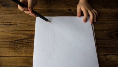 küçük çocuk beyaz kağıt üzerine çizer