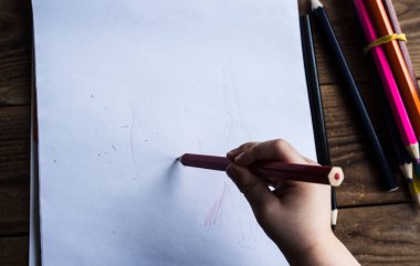 küçük çocuk beyaz kağıt üzerine çizer