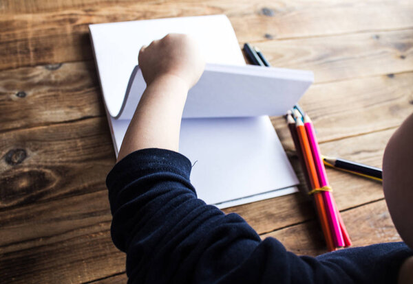 маленький мальчик рисует на белой бумаге
