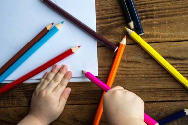 küçük çocuk beyaz kağıt üzerine çizer