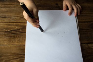 küçük çocuk beyaz kağıt üzerine çizer