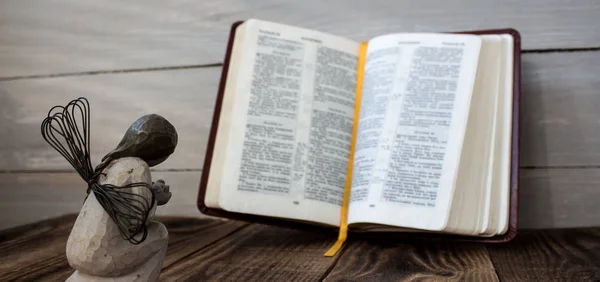 Angelo e Bibbia su uno sfondo di legno — Foto Stock