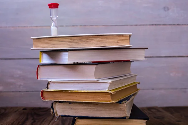 Pile of books and hourglass — Stock Photo, Image
