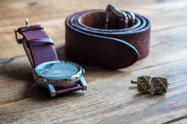 Mens saatler ve kemer ve cufflincs ahşap arka plan üzerinde