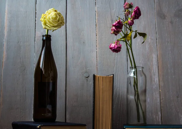 Rosas blancas y rojas en una botella y un libro — Foto de Stock